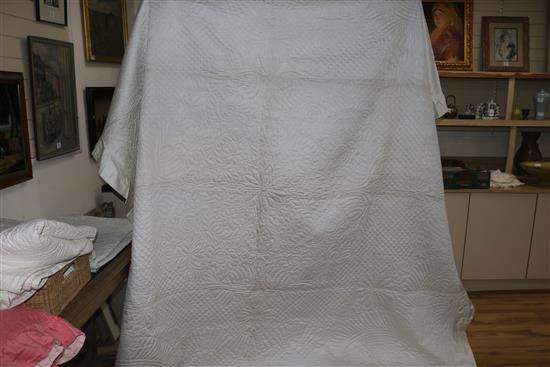 An off-white quilt with blue stitching, a reversible blue and cream quilt, a creamy oyster quilt and a mint green quilt (4)